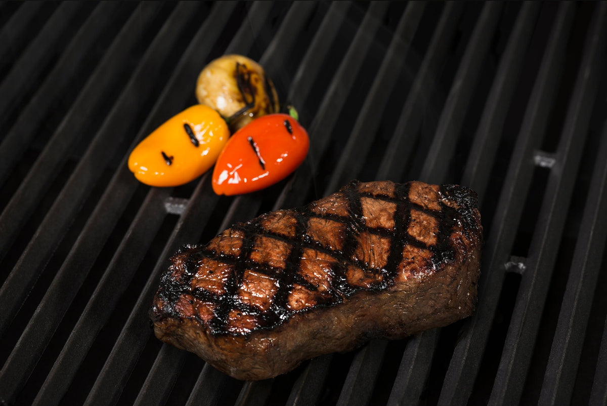 Steak and vegetables cooking on Baron and Crown cast iron grids