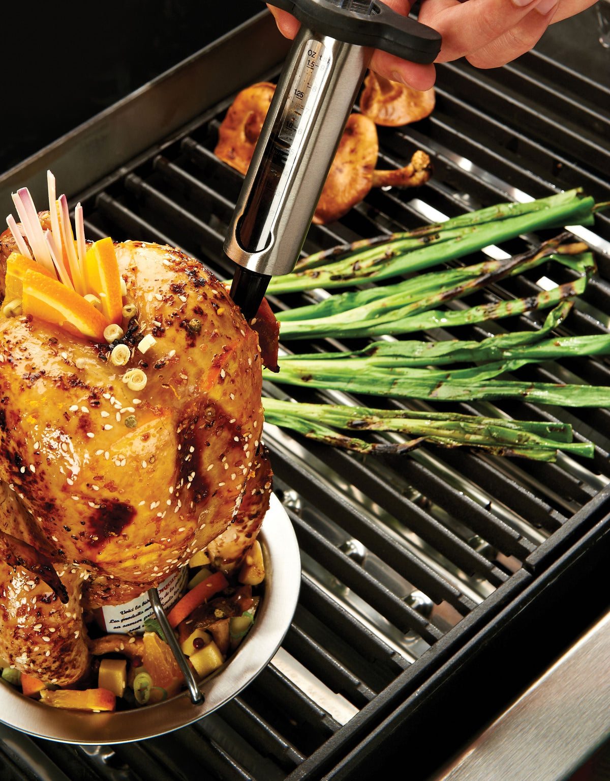 Marinade injector positioned over roast chicken