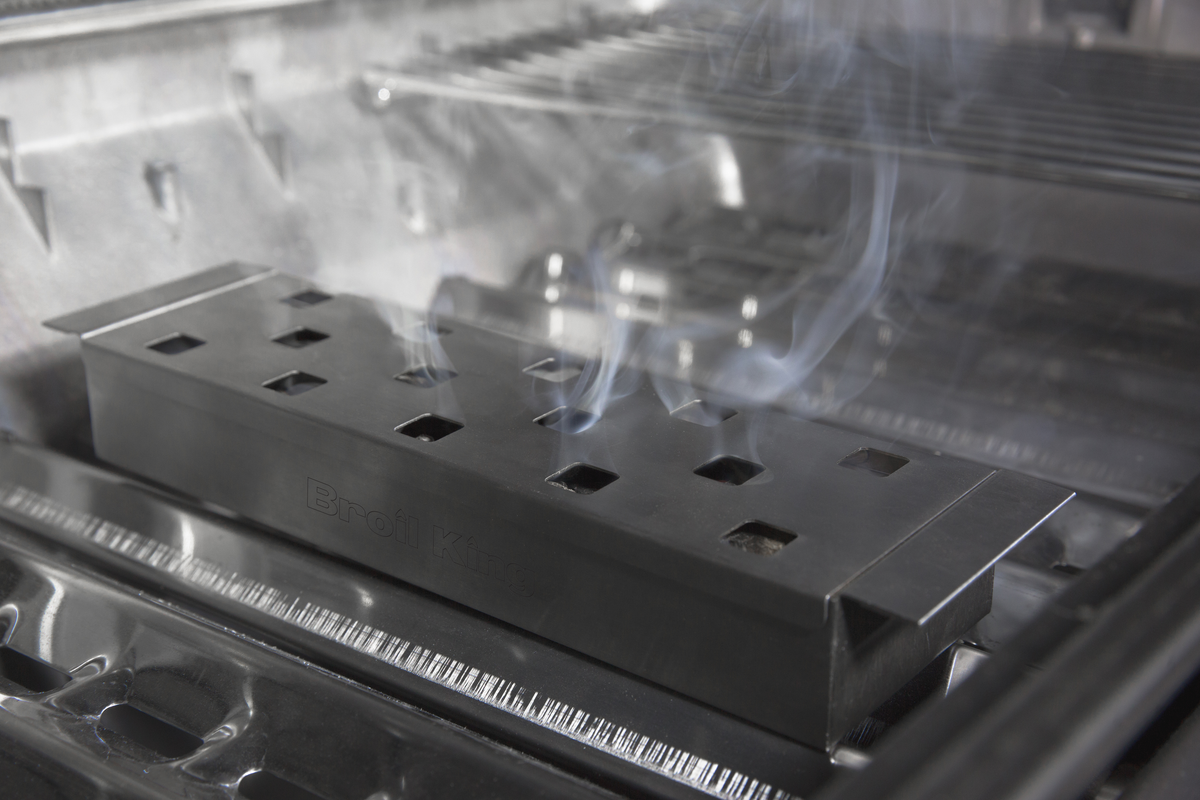 Smoker box producing smoke beneath the cooking grids