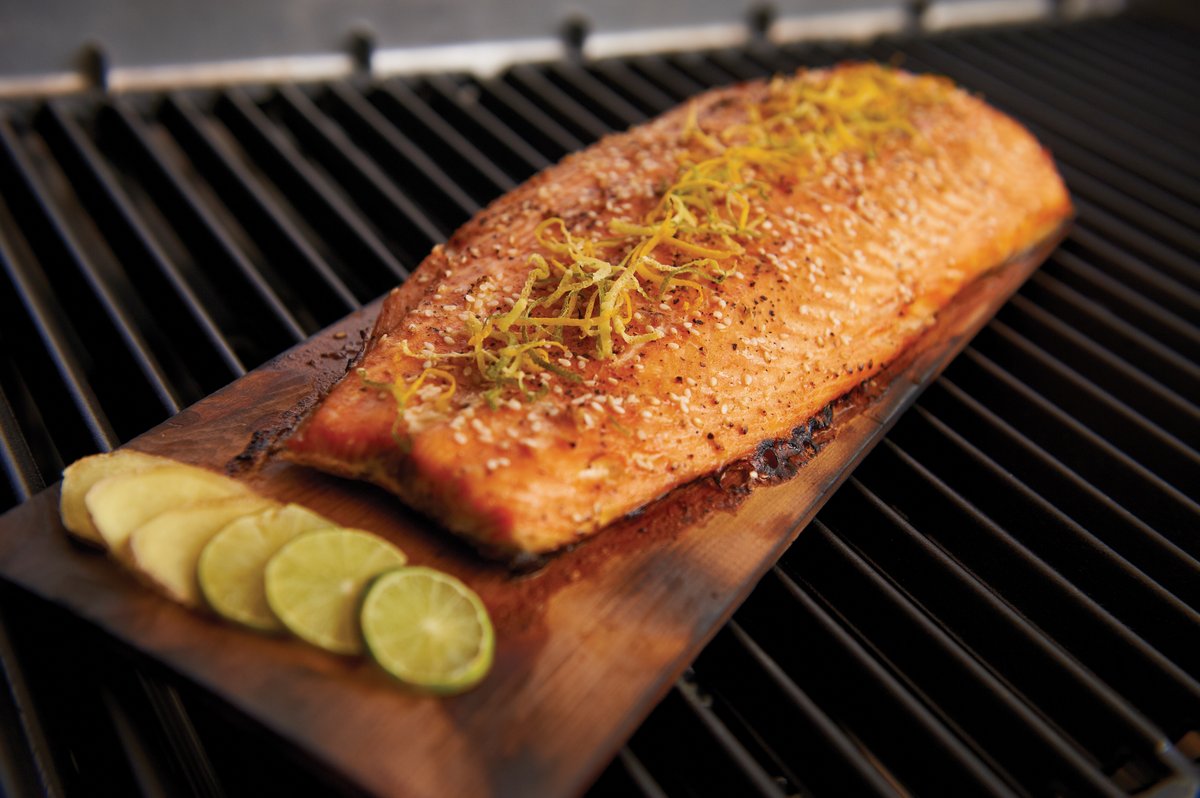 Salmon cooking on a cedar plank on the grill