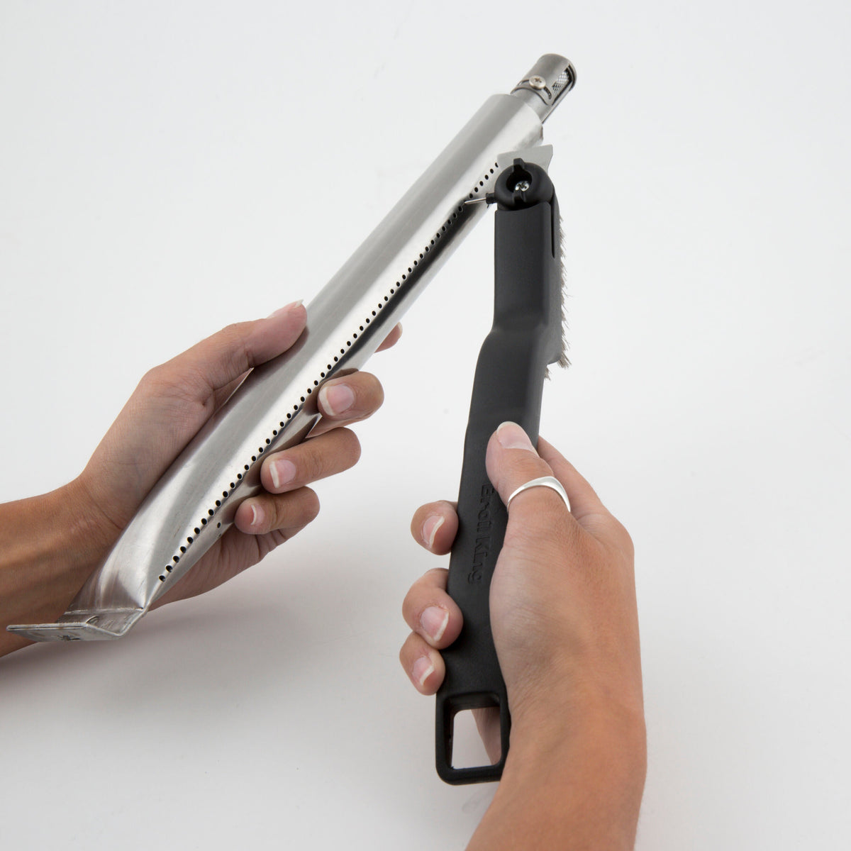 Burner maintenance brush being used on a removed burner tube