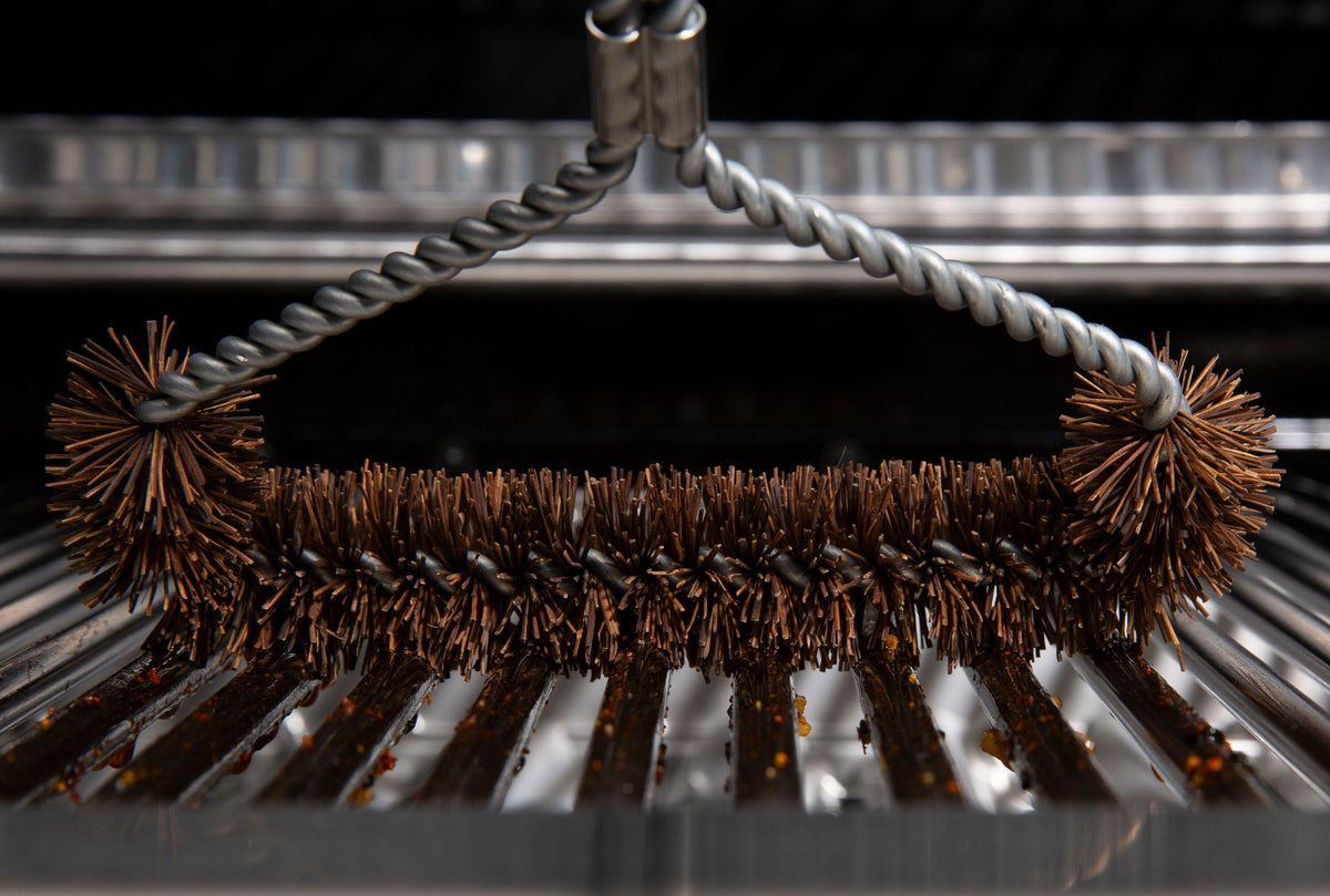 Tri-head Palmyra brush positioned on cooking grids