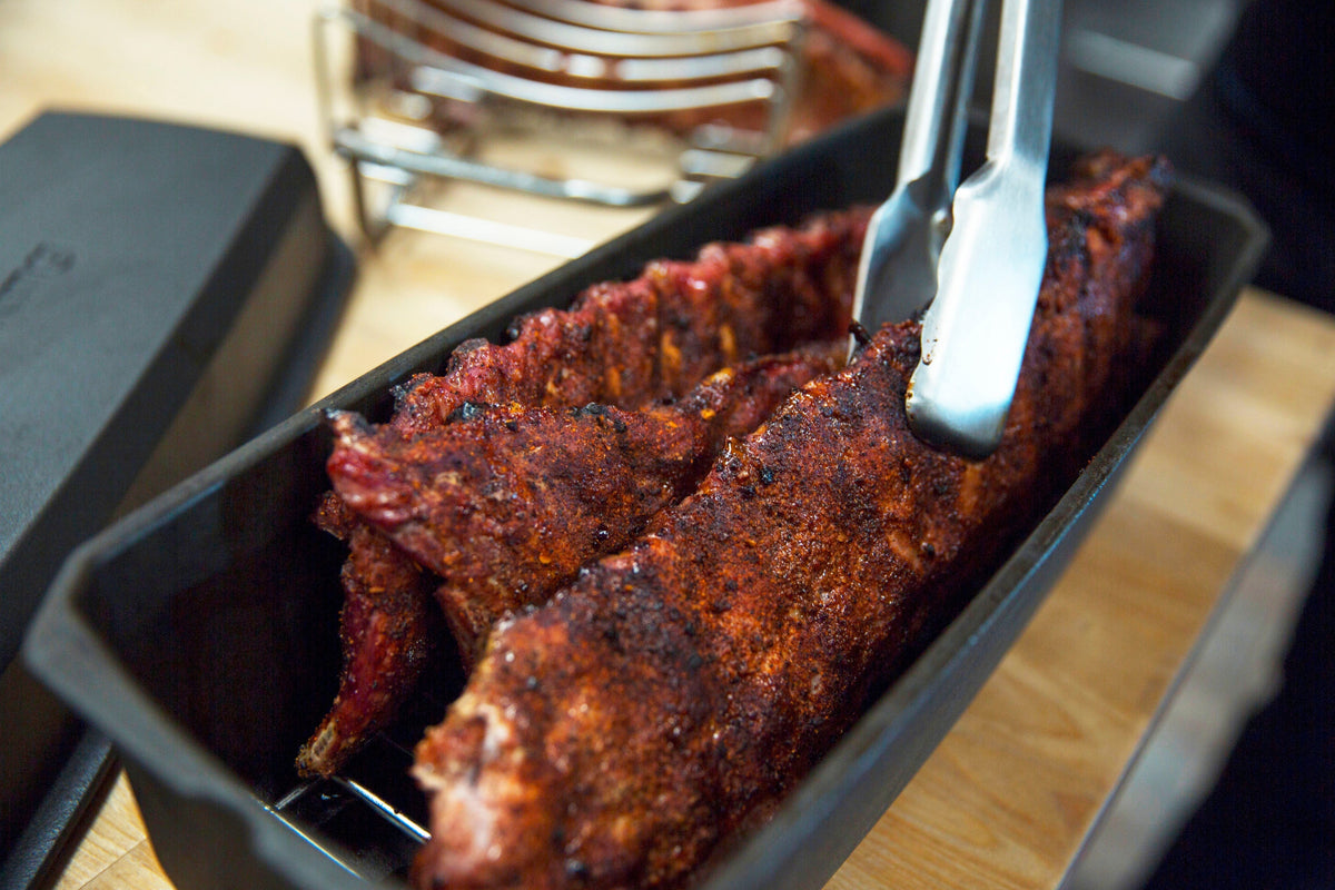 Tongs lifting ribs from a rib roaster