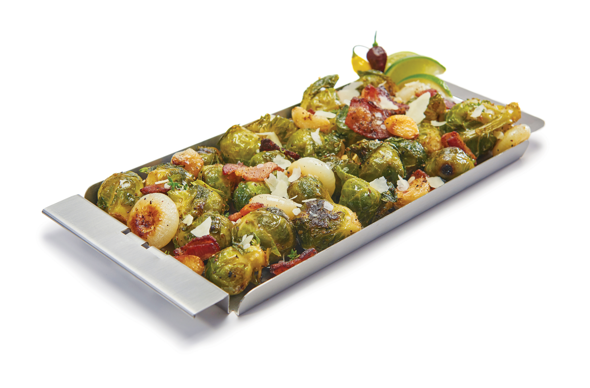 Vegetables arranged on a narrow stainless steel grill topper