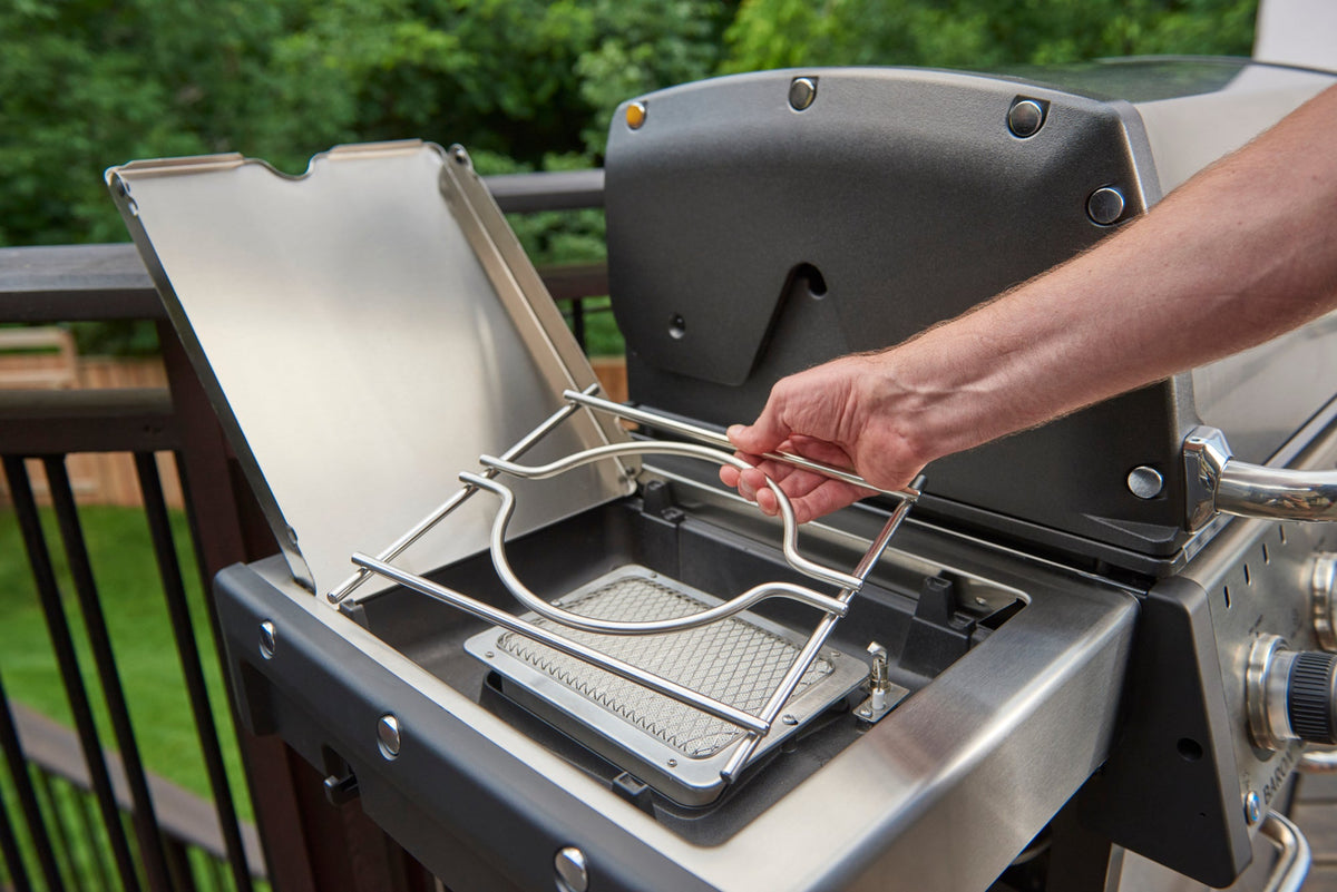 Hand positioning a wok ring over a gas side burner