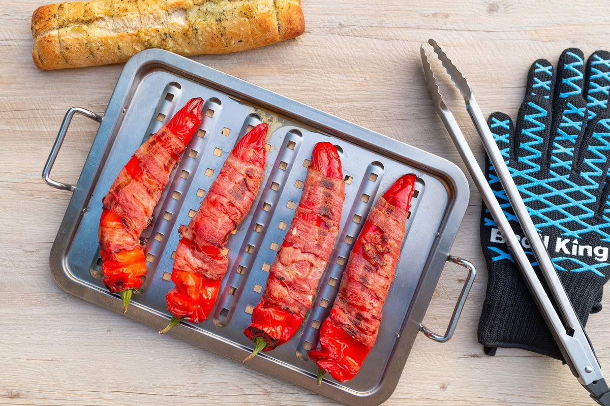Food skewers arranged on an Imperial stainless steel topper beside separate grilling tools