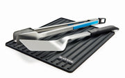 Grilling utensils resting on the silicone side shelf mat