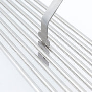 Cooking grid lifter positioned under stainless steel grill rods