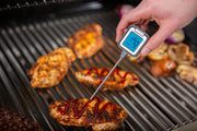 Instant-read thermometer measuring steak on the grill
