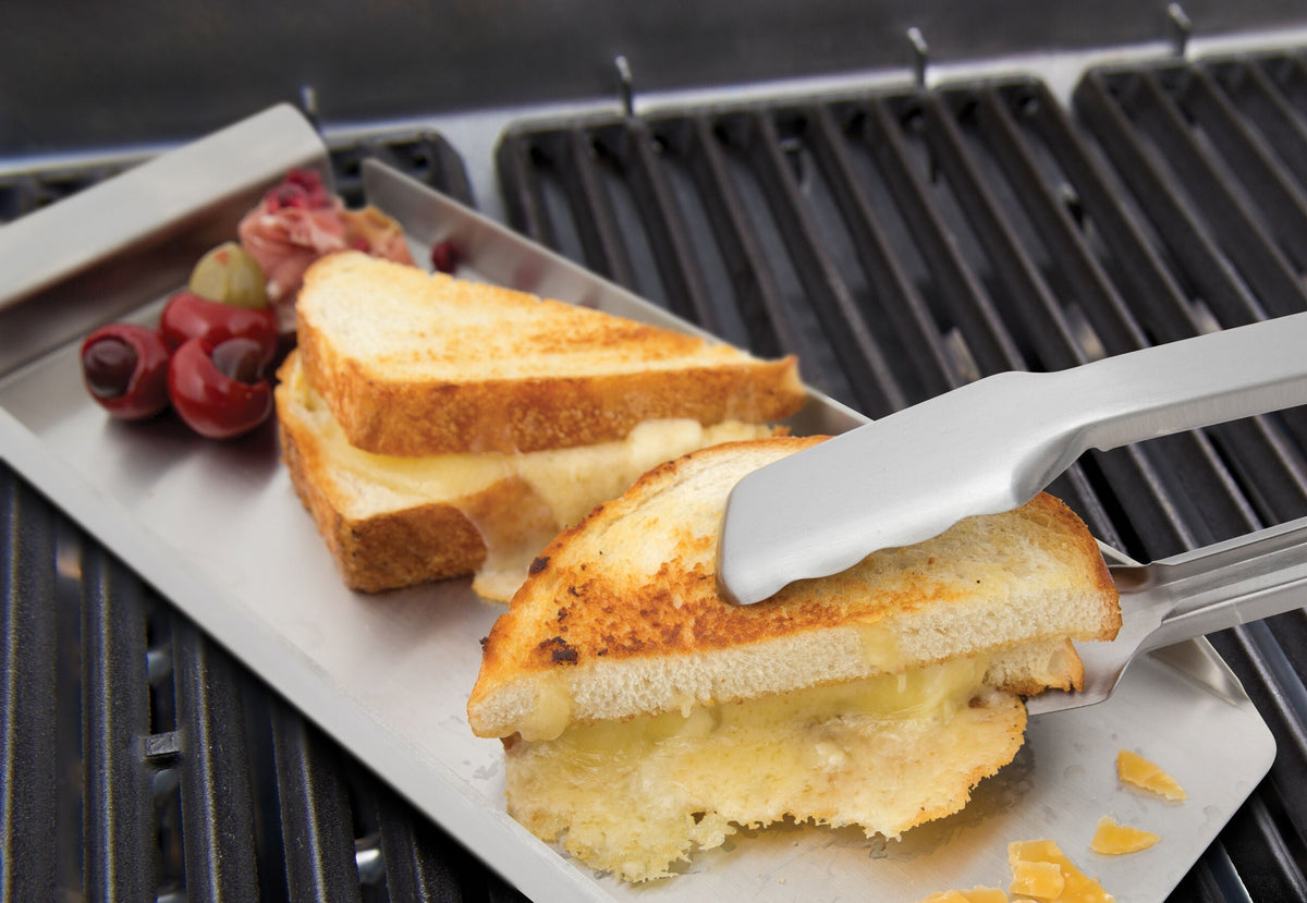 Baron tongs turning sandwiches on a narrow griddle