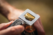 Bottle opener lifting the cap from a bottle