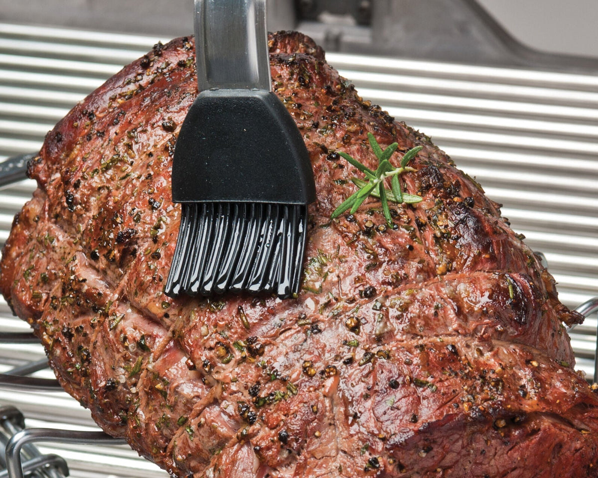 Silicone basting brush applying sauce to a roast
