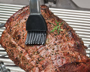 Silicone basting brush applying sauce to a roast