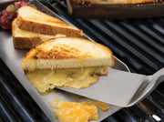 Baron turner lifting a grilled sandwich from a griddle