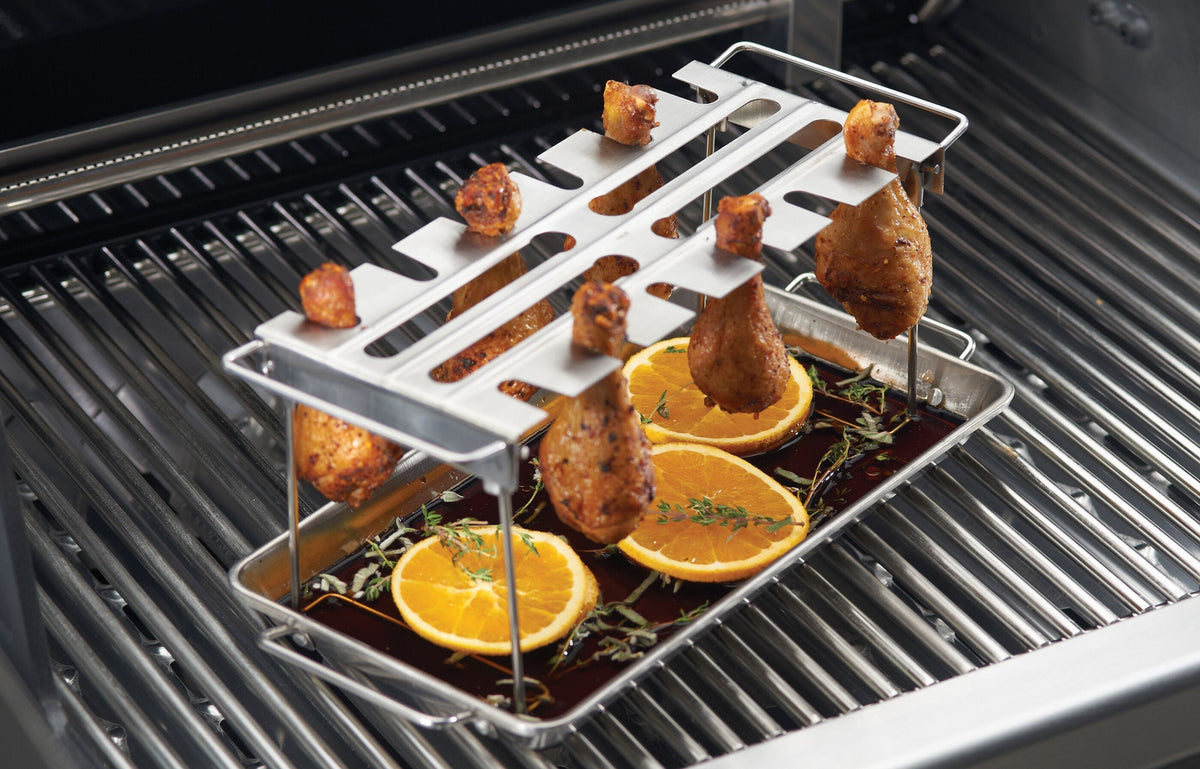 Chicken wings suspended over a collection pan on a wing rack