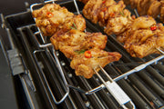 Skewer rack holding chicken kebabs above the cooking grids