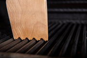 Wood scraper contacting cast iron cooking grids