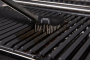 Coil spring brush being used on grill cooking grids