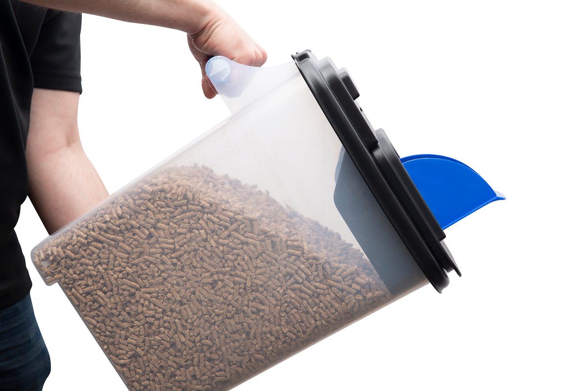 Person tilting the pellet fuel storage bin to pour its contents