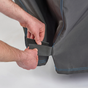 Hands securing the strap of a premium pellet-grill cover