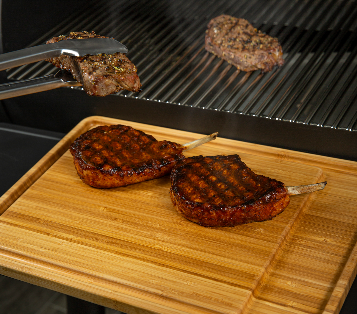 Cooked steaks resting on an Imperial bamboo serving board