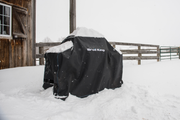 Covered grill standing outdoors in snow