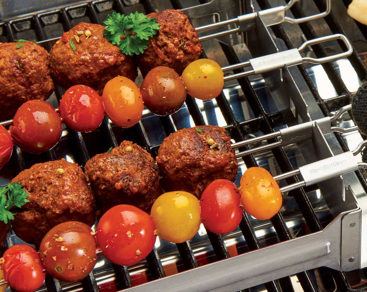 Meatballs and tomatoes on skewers in the narrow kebab rack