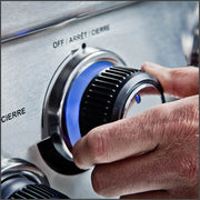 Hand turning a blue illuminated control knob