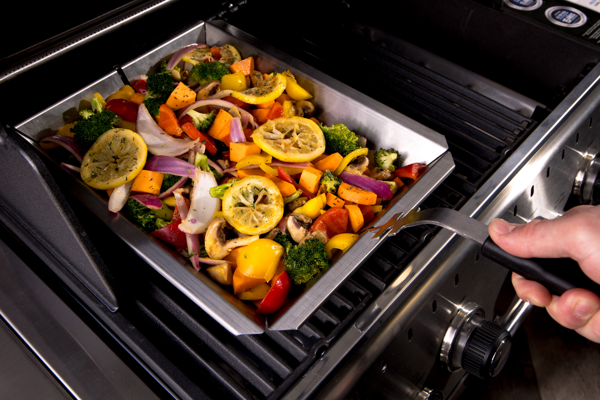 Vegetables being stirred in a stainless steel shelf insert wok