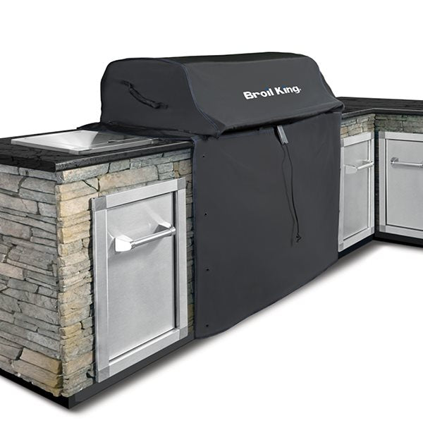 Protective cover over a built-in grill beside separate outdoor kitchen cabinets