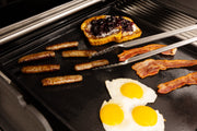Breakfast foods cooking on a plancha inside a grill