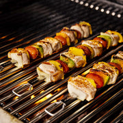 Skewers cooking on stainless steel rod cooking grids